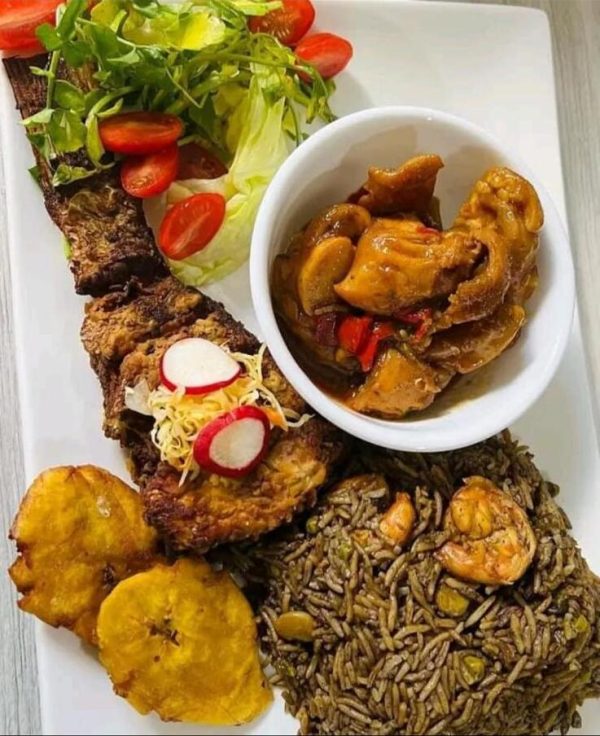Conches and fish served with black rice and fried plantain