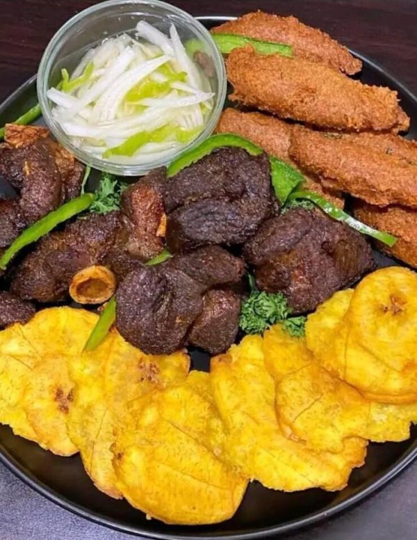 Griot, served with acra and fried plantain with pickles